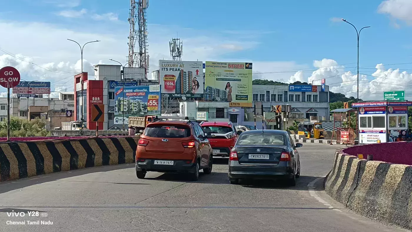 Outdoor media visible across a busy Chennai traffic junction