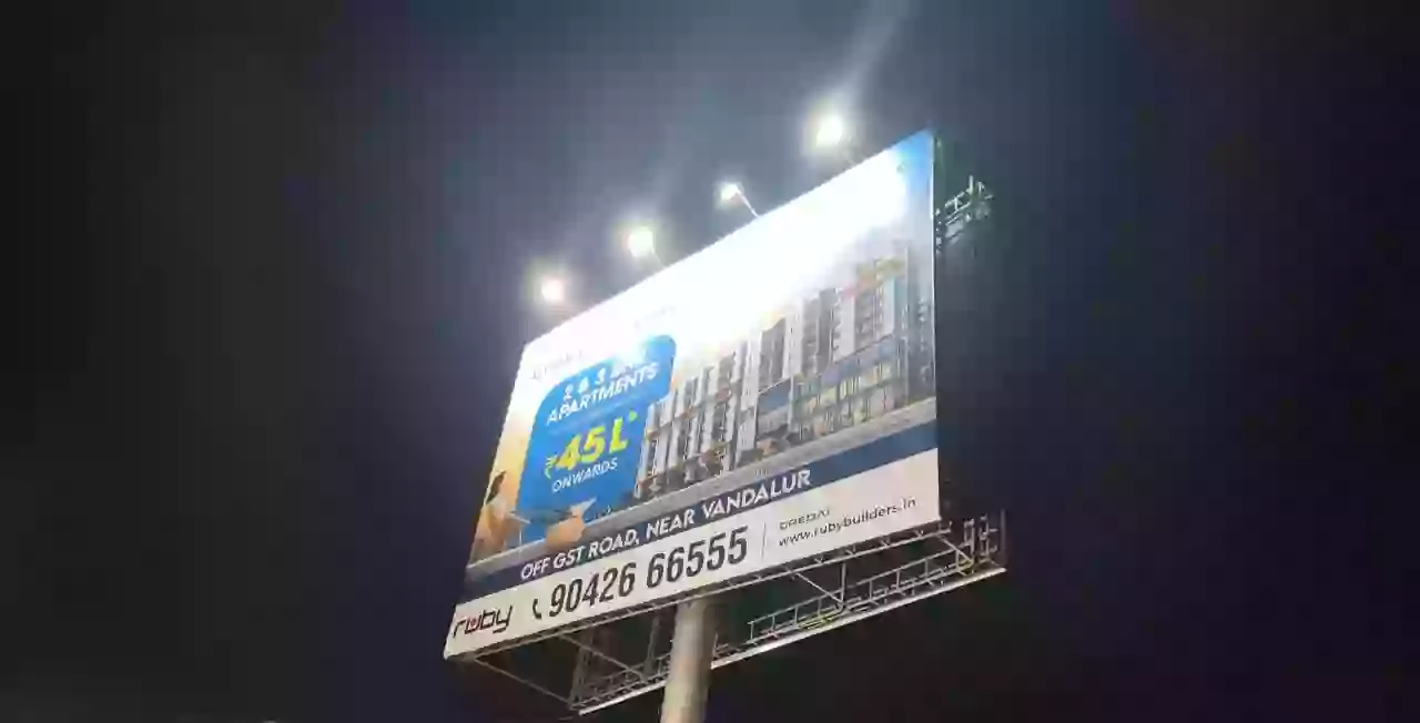 Illuminated roadside hoarding photographed at night in Padappai
