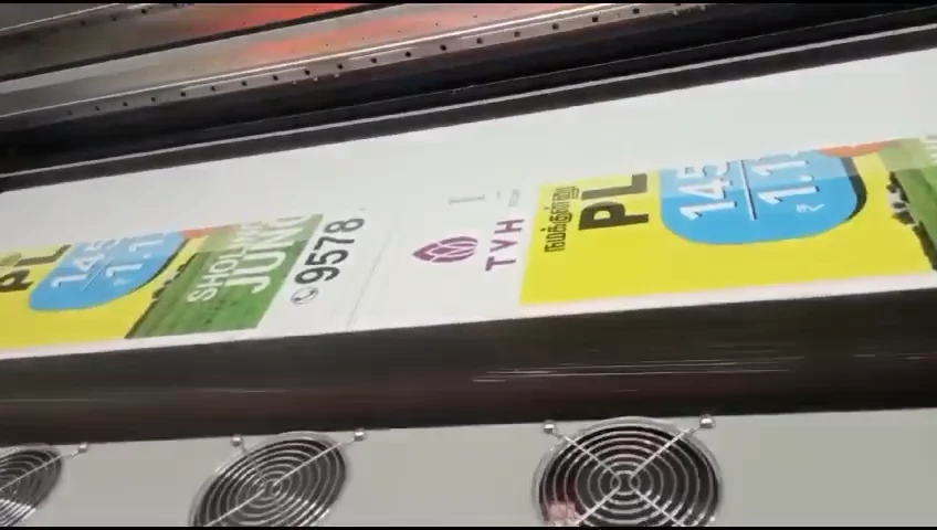 Real-estate campaign flex moving through the machine.